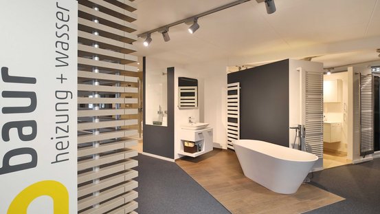 Der Ausstellungsraum zeigt ein zeitgemäßes Badezimmerdesign mit einer weißen Badewanne und einem minimalistischen Waschbecken.