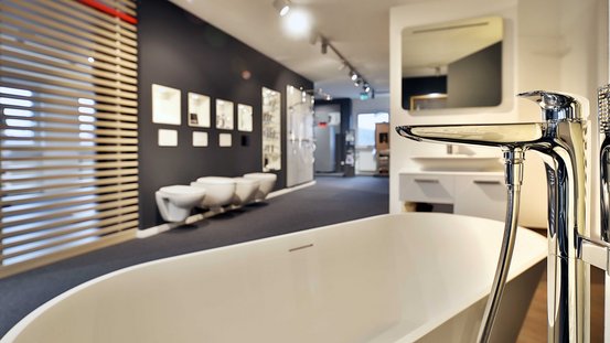 Ein modernes Badezimmer mit einer eleganten Badewanne und stilvollen Armaturen, umgeben von minimalistischen Wänden.