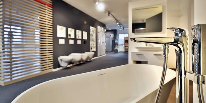 Ein modernes Badezimmer mit einer eleganten Badewanne und stilvollen Armaturen, umgeben von minimalistischen Wänden.
